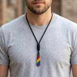 AI-generated model wearing the rainbow tie pendant necklace with a light grey shirt.