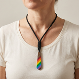 AI-generated model wearing the rainbow tie pendant necklace with an ivory top.