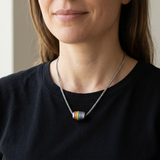 AI-generated lifestyle image of a woman wearing the Rainbow Orbit Barrel Necklace